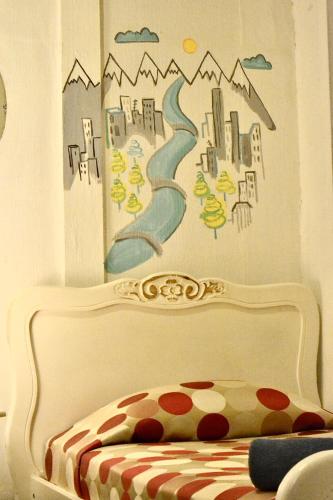 a bedroom with a bed with a painting on the wall at Hostal Providencia in Santiago