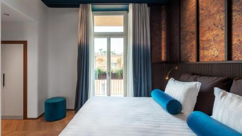 a bedroom with a large bed with blue pillows at Palazzo Velabro, a Member of Design Hotels in Rome