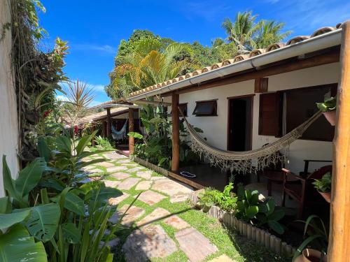 uma casa com uma rede em frente em Pousada Pandoro em Trancoso