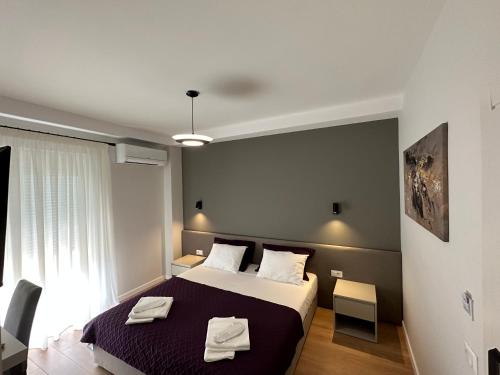 a bedroom with a bed with two towels on it at Soin Rooms in Tirana