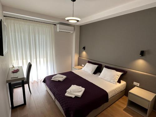 a bedroom with a bed with two towels on it at Soin Rooms in Tirana