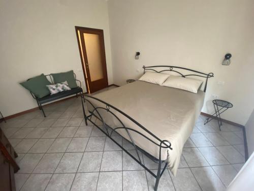 a bedroom with a large bed and a chair at I 3 Anelli Casa Vacanze in Foligno