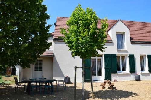 een tafel en stoelen voor een huis bij ô temps de l'escapade in Saint-Père-sur-Loire