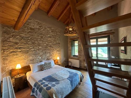 a bedroom with a bed and a stone wall at Pritanio in Polídhroson