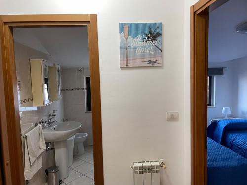 a bathroom with a sink and a toilet and a mirror at IL SOGNO DEL MARE in Montesilvano