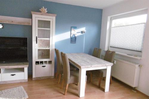 une salle à manger avec une table, des chaises et une télévision dans l'établissement Ruegen Fewo 70, à Dreschvitz