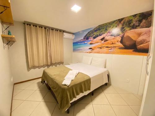 een slaapkamer met een bed met een schilderij aan de muur bij Ed. Crystal Residence in Vila Velha