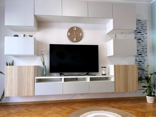 uma sala de estar com televisão numa parede branca em Morskie Boho Gdynia Rental em Gdynia
