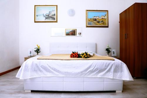 サッサリにあるSogno Allegroのベッドルーム1室(白いベッド1台、フラワーアレンジメント付)