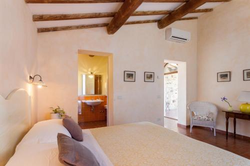 サトゥルニアにあるAgriturismo Bio Aia Della Colonnaのベッドルーム(大型ベッド1台付)、バスルームが備わります。