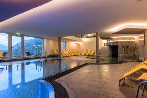 a swimming pool in a hotel with yellow chairs at Hapimag Ferienwohnungen Bad Gastein in Bad Gastein