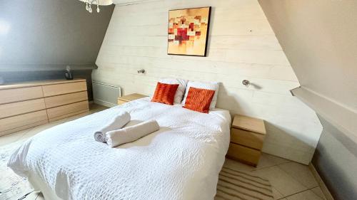 a bedroom with a bed with orange and white pillows at DEAUVILLE LES YEARLING Appartement duplex 2 chambres 4 pers Balcon Plein Sud in Deauville
