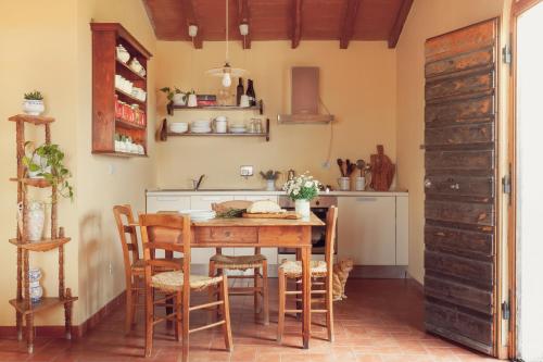 a kitchen with a wooden table and chairs at Agriturismo Bio Aia della Colonna in Saturnia