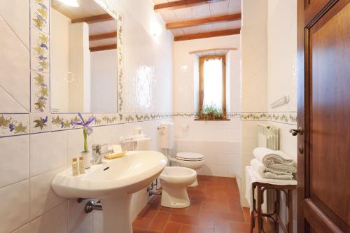 ein weißes Bad mit einem Waschbecken und einem WC in der Unterkunft Agriturismo Bio Aia Della Colonna in Saturnia