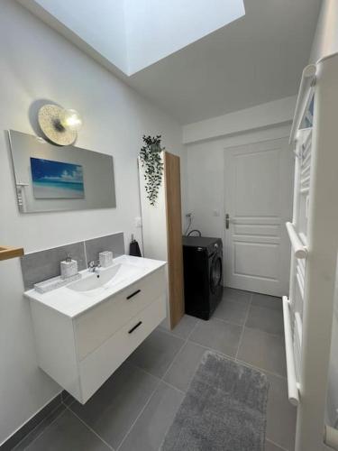 un bagno bianco con lavandino e porta di Appartement T2 La Ferté Gaucher à 200m du centre a La Ferté-Gaucher
