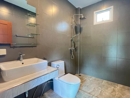 een badkamer met een wastafel, een toilet en een douche bij 拉威查龙山顶大佛三卧泳池别墅Thaiya Villa in Ban Klang