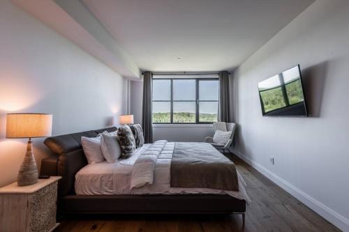 ein Schlafzimmer mit einem großen Bett und einem Fenster in der Unterkunft Horizon 1-203 / Warm and cozy condo with a view! in Mont-Tremblant
