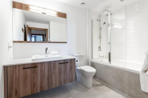 ein Badezimmer mit einem Waschbecken, einem WC und einer Badewanne in der Unterkunft Horizon 1-203 / Warm and cozy condo with a view! in Mont-Tremblant