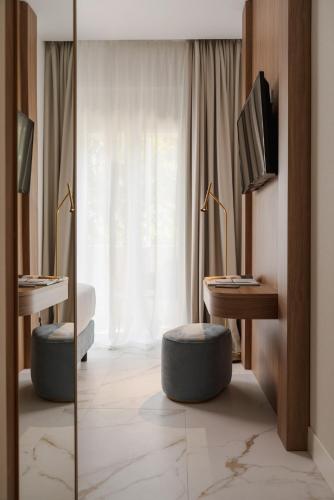 a hotel room with two beds and a desk and a television at Parioli Hotel Rimini in Rimini
