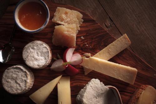 a plate of cheese and meats and a cup of sauce at Agriturismo Bio Aia della Colonna in Saturnia