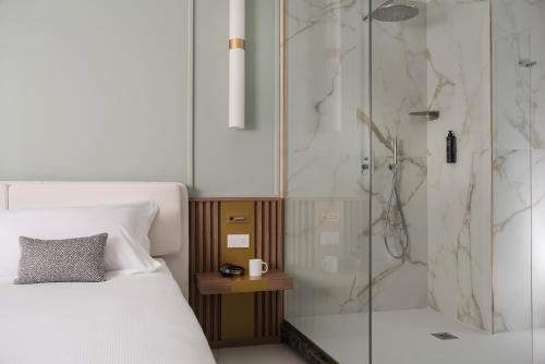 een slaapkamer met een douche en een bed bij Parioli Hotel Rimini in Rimini