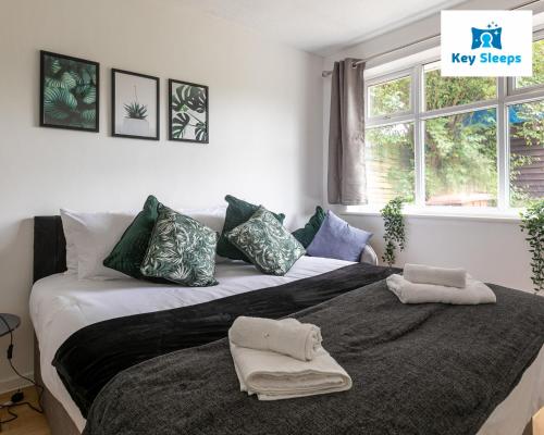 a bedroom with a large bed with a laptop on it at Keysleeps - Stunning Bungalow & Contractors & Leisure & Private Parking & Garden - Pelsall in Pelsall