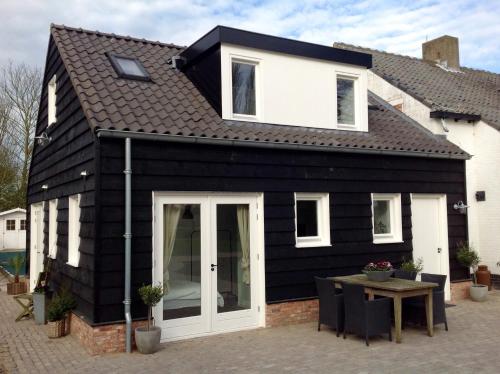 a black and white house with a table at Bed & Breakfast Zeeland in Renesse