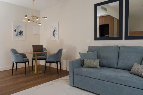 a living room with a blue couch and a table at Parioli Hotel Rimini in Rimini