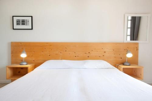 sypialnia z dużym białym łóżkiem z 2 lampami w obiekcie LELA'S w mieście Kardamyli