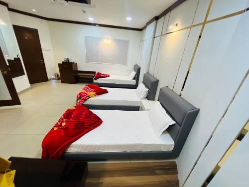 a room with three beds in a room at Hotel Majestic in Kolkata