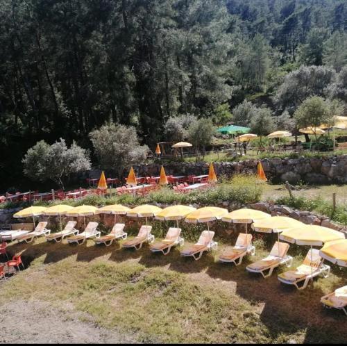 a group of chairs and tables with umbrellas at Köyceğiz Sultaniye Camping in Mugla