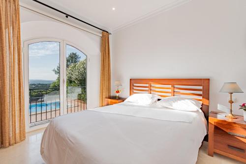 a bedroom with a bed and a large window at Arcos Gardens Sol Rent Golf in Arcos de la Frontera