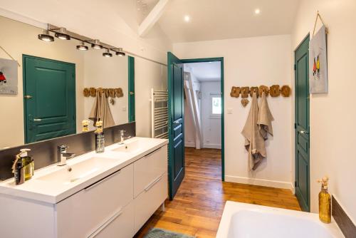 a bathroom with two sinks and a large mirror at Domaine du Pré de l'étang in Montazeau