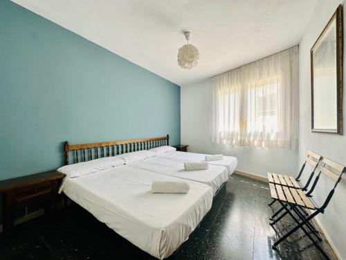 a bedroom with a large bed and two chairs at Book Mercurio Salou in Salou