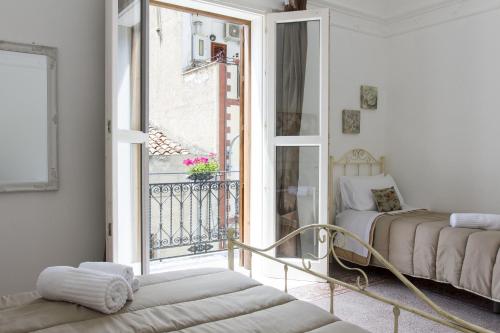 a room with a balcony with a bed and a window at TAM Vacanze B&B in Cinisi