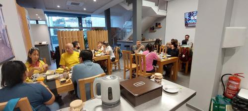 a group of people sitting at tables in a restaurant at Praza Camelias in Sarria