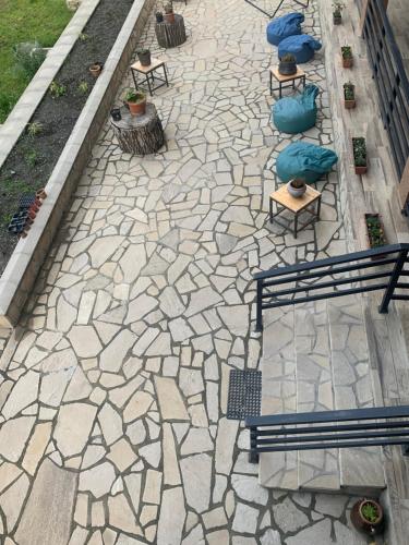 a stone patio with benches and chairs on it at Guest House Oxygen in Kazbegi