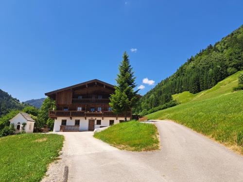 a house on a hill next to a dirt road at Müllner Appartements in Thiersee