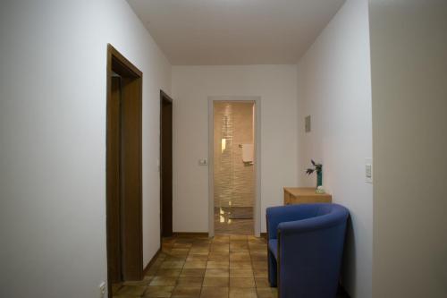 - un couloir avec une chaise bleue dans l'établissement Apartma Marin, à Portorož