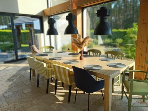 a dining room with a wooden table and chairs at LALA Kłączno małe SPA in Kłaczno