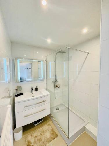 une salle de bain blanche avec une douche et un lavabo dans l'établissement Climatisé 2 pièces Vue Mer terasse Parking, à Roquebrune-Cap-Martin