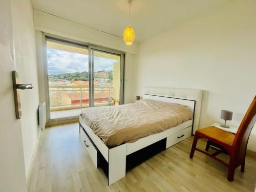 une chambre avec un lit et une grande fenêtre dans l'établissement Climatisé 2 pièces Vue Mer terasse Parking, à Roquebrune-Cap-Martin