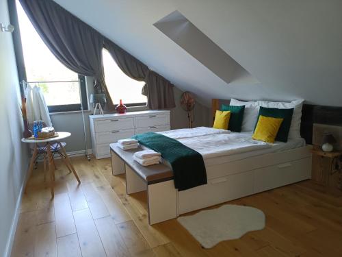 a bedroom with a white bed with yellow and green pillows at LALA Kłączno małe SPA in Kłaczno