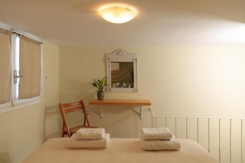 納克索喬拉的住宿－Green Loft room in Naxos Chora，一间卧室配有一张床、一把椅子和镜子