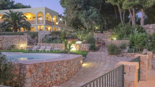 una casa con una pared de piedra y una piscina en Villa Opunzie Torre Vado, en Torre Vado