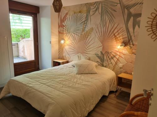 1 dormitorio con 1 cama grande y pared en Appartement Rez-de-jardin Terrasse, en Aulus-les-Bains