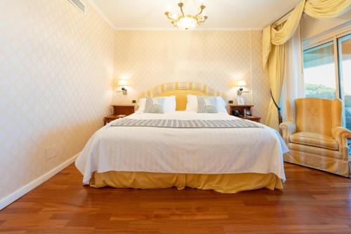 a bedroom with a large bed and a chandelier at Grand Hotel Del Mare Resort & Spa in Bordighera