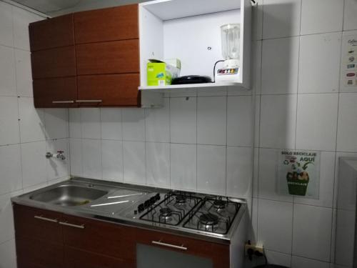 una cucina con lavello e fornello forno superiore di Habitación Privada y Confortable cerca a Centro Mayor y al Centro Histórico a Bogotá