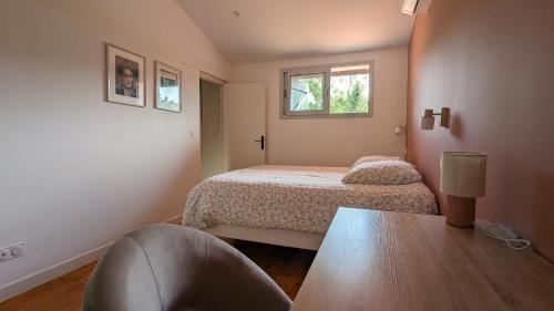 a small bedroom with two beds and a table at Maison au bord de la rivière Aveyron - Bruniquel in Bruniquel