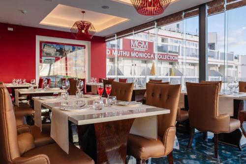 a restaurant with tables and chairs and a window at Monicca Collection Suites and Residences in Albufeira
